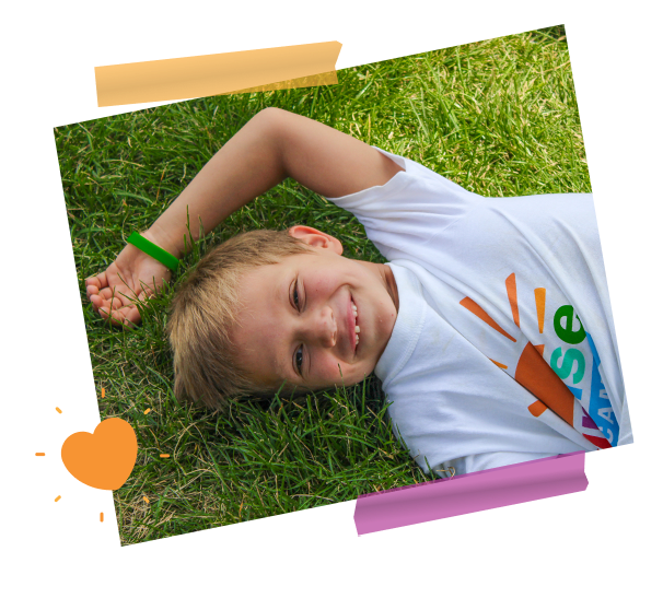 boy laying on grass smiling
